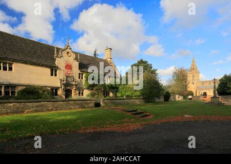 The Old Almshouses and St Marys parish church, Weekley village, Northamptonshire, England, UK Stock Photo