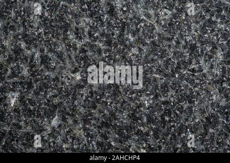 A close up macro photo of roughly cut black granite prior to polishing Stock Photo