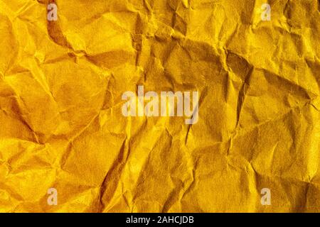 A close up abstract macro photo of crumpled creased paper lit with an orange flash gel Stock Photo
