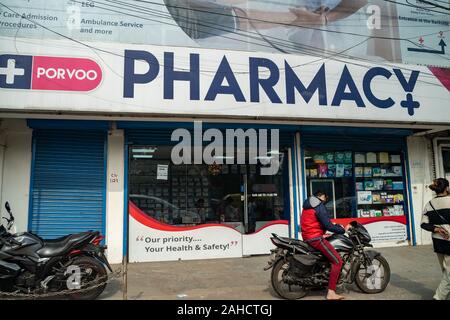 New Delhi, India - December 28, 2019: Outside, exterior view of the Porvoo Pharmacy store, as a customer on a motorbike drives by Stock Photo