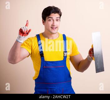 The young contractor employee applying plaster on wall Stock Photo