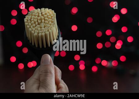Bristle kitchen dish scrubbing brush with red bokeh in the background. Copyspace available Stock Photo