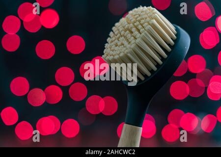 Bristle kitchen dish scrubbing brush with red bokeh in the background. Copyspace available Stock Photo