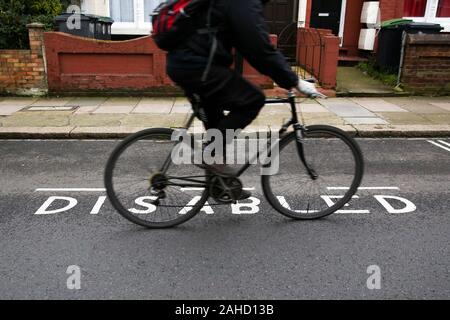 London, UK. 28th Dec, 2019. A cyclist rides by a disable parking bay in north London.Thousands of people with hidden disabilities have been given blue badge parking permits since new rules were introduced. Credit: Dinendra Haria/SOPA Images/ZUMA Wire/Alamy Live News Stock Photo