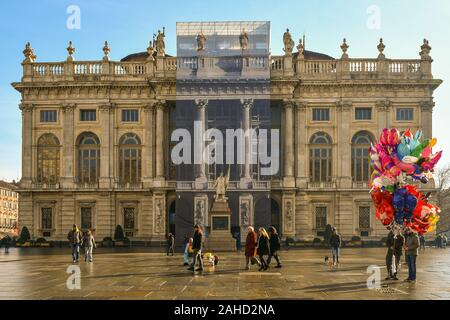 Palazzo Madama by Filippo Juvarra with people walking and a balloon seller in a sunny winter day in Piazza Castello square, Turin, Piedmont, Italy Stock Photo