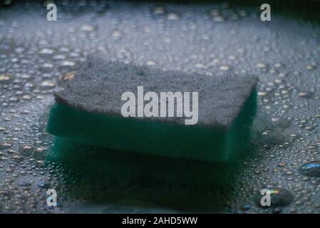 Dish washing sponge and scourer in soapy bubbles Stock Photo