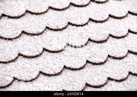 Pattern of a closeup of a roof with plane tiles covered with a thin layer of snow. Seen in Germany in December Stock Photo