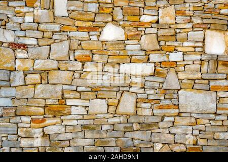 Wall of stones as a texture. Stone wall. Wall of stones. wall of a medieval fortress with mainly white or light colored stones of varying sizes and shapes, usable as background pattern or for designs Stock Photo