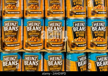 Tins of different varieties of Heinz Baked Beans for sale on the shelves of a Canadian supermarket.
