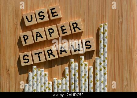 Use Paper Straws, words in 3d wooden alphabet letters on a wood background with straws Stock Photo