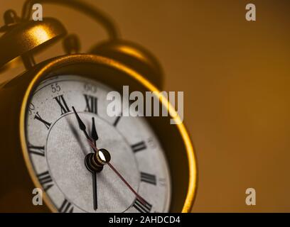 Golden vintage alarm clock showing five to twelve Stock Photo