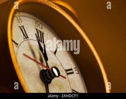 Golden vintage alarm clock showing five to twelve Stock Photo