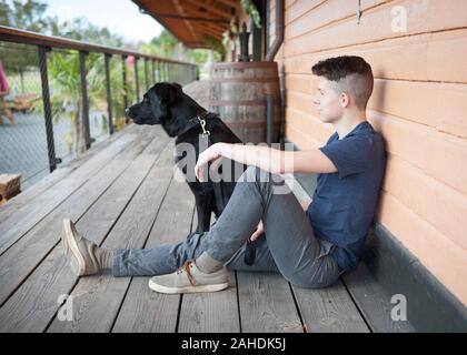 Boy and his dog on porch Stock Photo