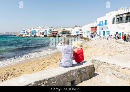 Mykonos, Greece - May 2018: elderly couple overlooking the island old town district Stock Photo