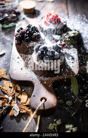 Fruit muffins with powdered sugar.Photo on an old table.Healthy food and drink Stock Photo