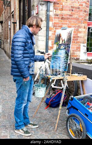 Artist painting a scene on the street in Bruges, Belgium Stock Photo