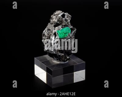 rock with raw emerald crystal with black background Stock Photo