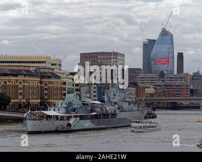 Museum ship light cruiser HMS Belfast on Thames River in front of Hay's Galleria in Southwark, with London Bridge and skyscrapers in the background. Stock Photo