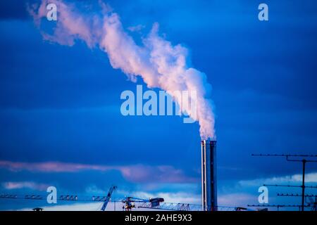 Atmospheric Air Pollution From Industrial Smoke billowing from Smoking pipes and cranes beside smoking pipes, ecology problems paris france Stock Photo