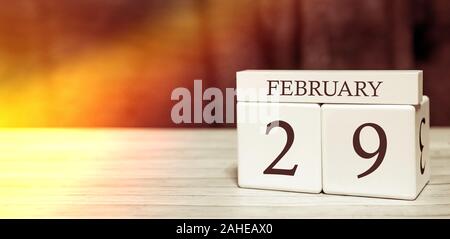 Calendar reminder event concept. Wooden cubes with numbers and month on February 29 with sunlight. Stock Photo