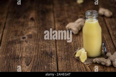 Healthy Ginger Sap on a wooden table as detailed close-up shot (selective focus) Stock Photo