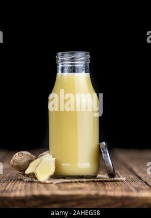 Healthy Ginger Sap on a wooden table as detailed close-up shot (selective focus) Stock Photo