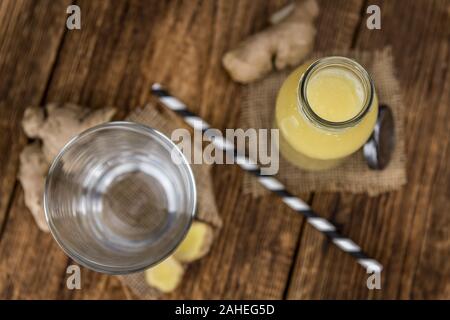 Healthy Ginger Sap on a wooden table as detailed close-up shot (selective focus) Stock Photo