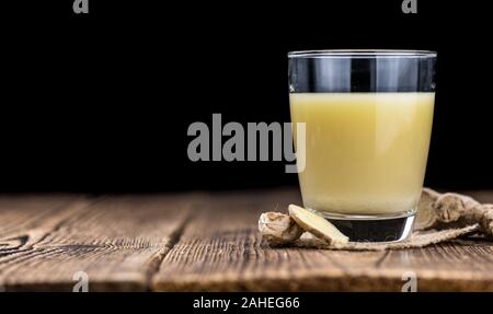 Healthy Ginger Sap on a wooden table as detailed close-up shot (selective focus) Stock Photo