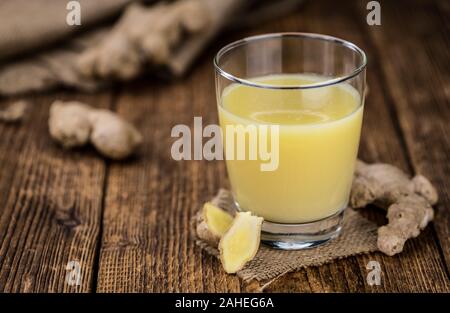 Healthy Ginger Sap on a wooden table as detailed close-up shot (selective focus) Stock Photo
