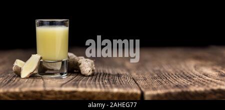 Healthy Ginger Sap on a wooden table as detailed close-up shot (selective focus) Stock Photo