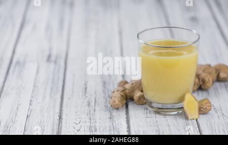 Healthy Ginger Sap on a wooden table as detailed close-up shot (selective focus) Stock Photo