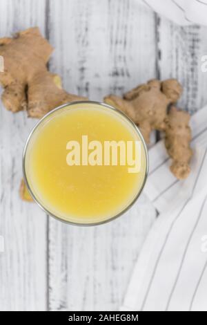Healthy Ginger Sap on a wooden table as detailed close-up shot (selective focus) Stock Photo