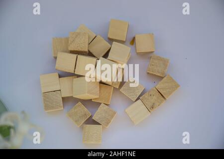 Pile of wooden blocks on pale purple background, small cubes made from wood Stock Photo