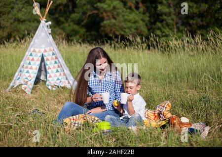 Mom and son on a picnic in the woods in nature Stock Photo