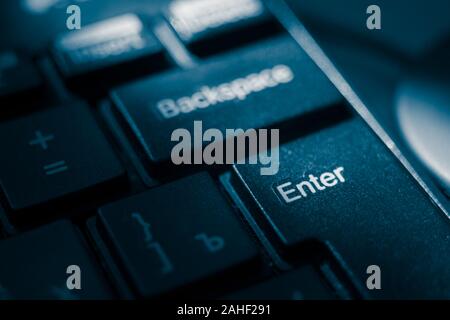 Black shiny keyboard closeup, focus on the Enter key. Stock Photo