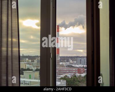 Smoking factory big black pipe.View from the Window. Smoke from pipe, cloudy sky. Rainy day. Sky panorama for backdrop wallpaper, desktop. Copy space. Concept of ecology problems. Filtered image. Stock Photo