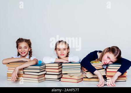 three girls at school in the classroom for books of knowledge Stock Photo