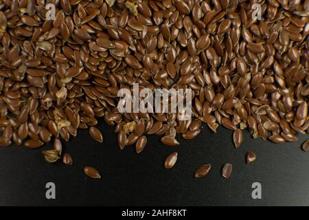 Linum usitatissimum is scientific name of Brown Flax seed. Also known as Linseed, Flaxseed and Common Flax. Closeup of grains, background. Stock Photo