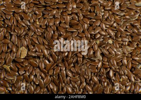 Linum usitatissimum is scientific name of Brown Flax seed. Also known as Linseed, Flaxseed and Common Flax. Closeup of grains, background. Stock Photo