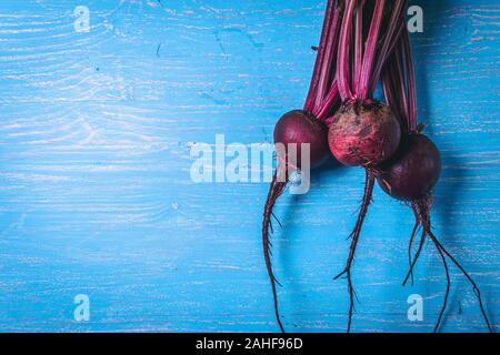 A bunch of fresh beets on old blue wooden table. Copy space. Healthy food. Raw Vegetables. Stock Photo