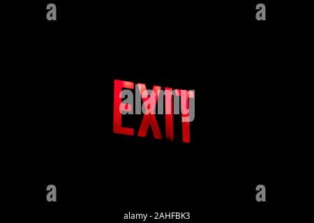 Bright red emergency exit sign on black background Stock Photo