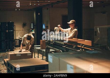 Italy, Milan, May 30, 2019: Conveyor for packing coffee beans at Starbucks Reserve in Milan. The technological process with employees. Stock Photo