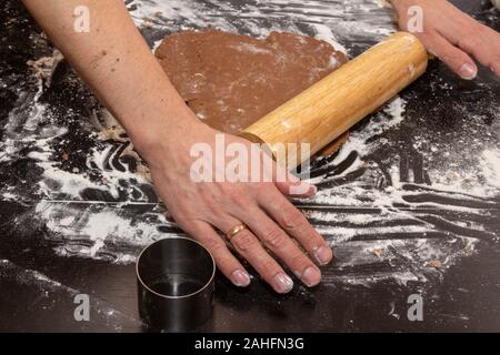Rolling dough for gingerbread cookie. Rolling pin in male hands. Close-up Stock Photo