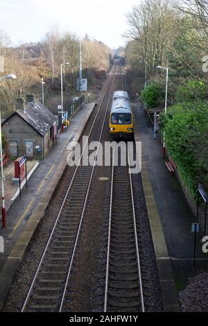 A Sheffield to Huddersfield Pacer Class 144 Metro train stops at Stocksmoor unmanned railway station in West Yorkshire, England Stock Photo