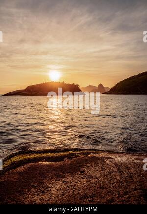 View over rocks of Piratininga towards Rio de Janeiro, sunset, Niteroi, State of Rio de Janeiro, Brazil Stock Photo