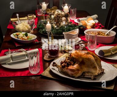 Close up of a Christmas dinner table complete with turkey and all the fixings including gravy and cranberry sauce. Stock Photo