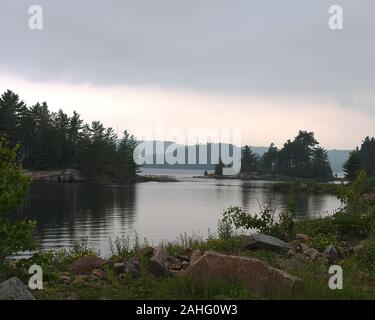 Beautiful scenery of summer season showing trees, water, river, lake, cloudy clouds, foliage, rocks in its tranquility environment. Stock Photo