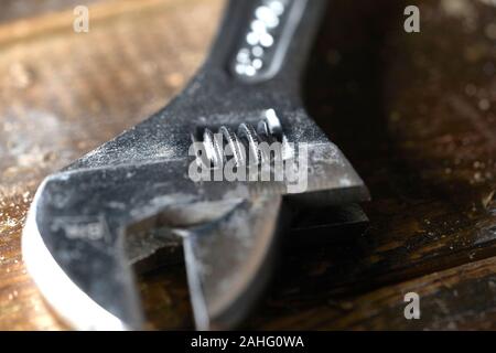 Adjustable wrench isolated on wooden background . Macro photography Stock Photo