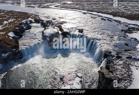 Aerial view of Godafoss waterfall, snowy shore and river. Iceland in early spring Stock Photo