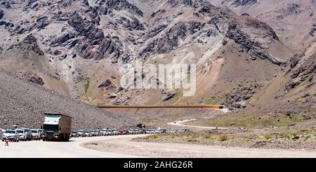 A queue of traffic waiting to leave Argentina and enter Chile at the border crossing in the Andes. Stock Photo